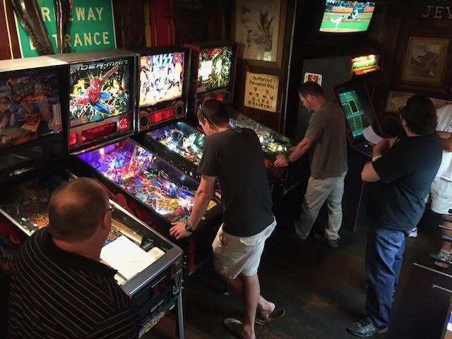 Players spread across several machines in a room hung with neon signs
